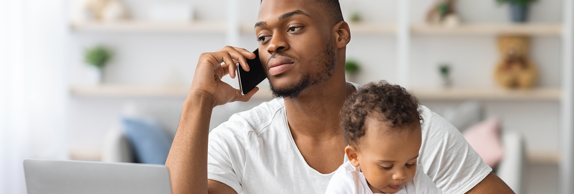 Busy Black Man Working Remotely At Home With Little Baby On Hands