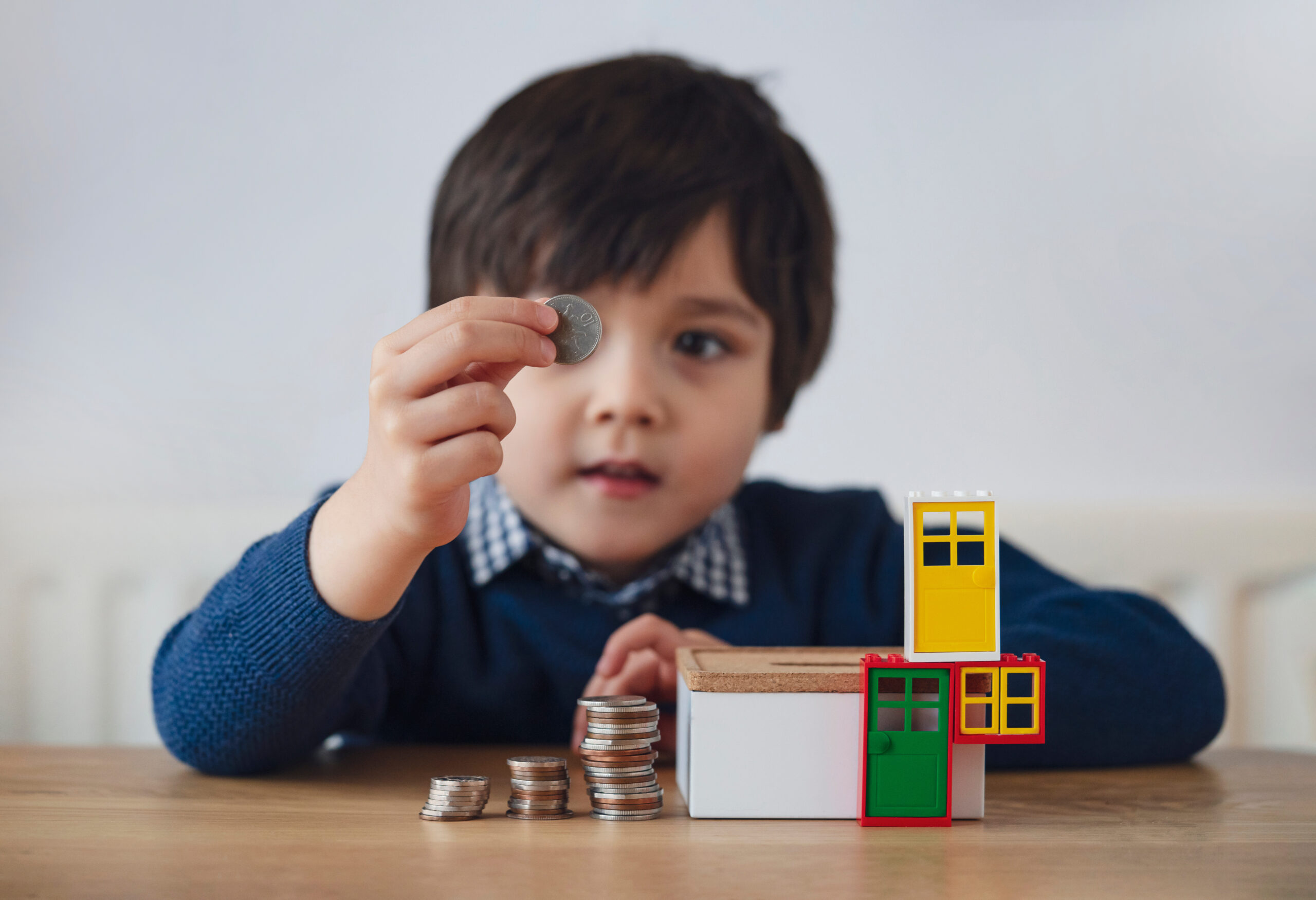 kid boy making stack money coins and counting before puting in box