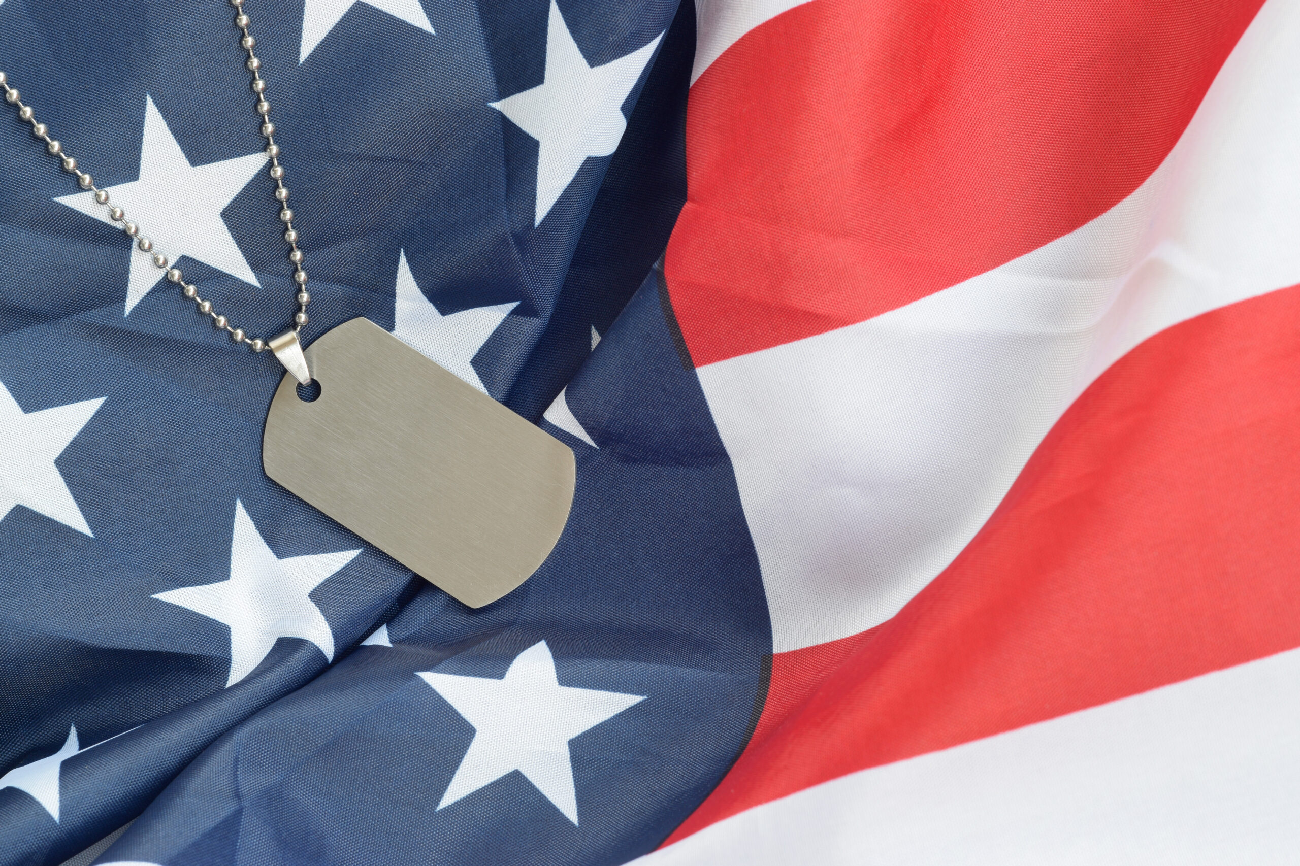 Silvery military beads with dog tag on United States fabric flag