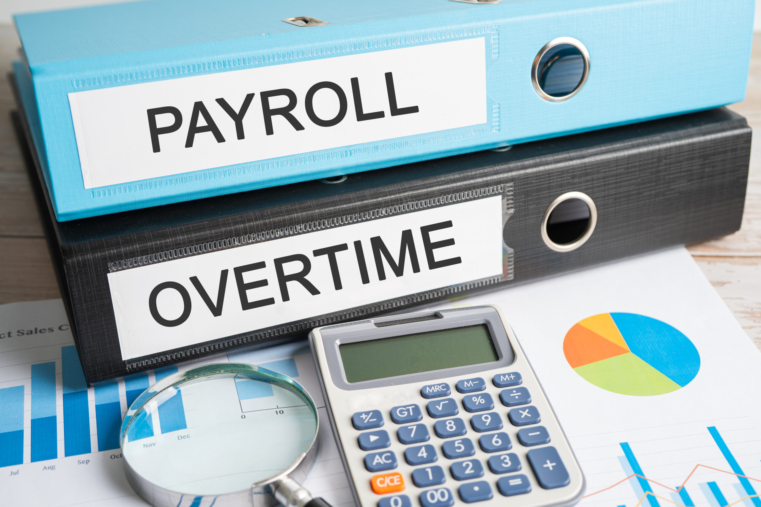 Payroll, Overtime. Binder data finance report business with graph analysis in office.